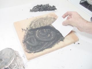 Scraping up powdered charcoal